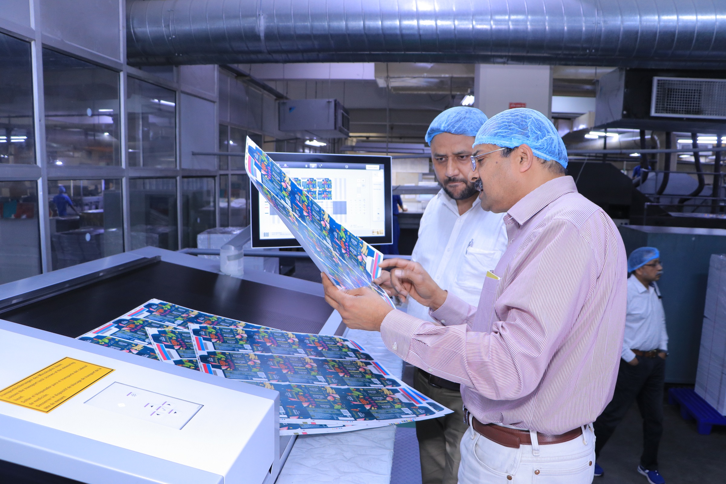 (In Picture): Mr. Sandeep Bhargava, inspecting a printed sheet on the Prinect Image Control station